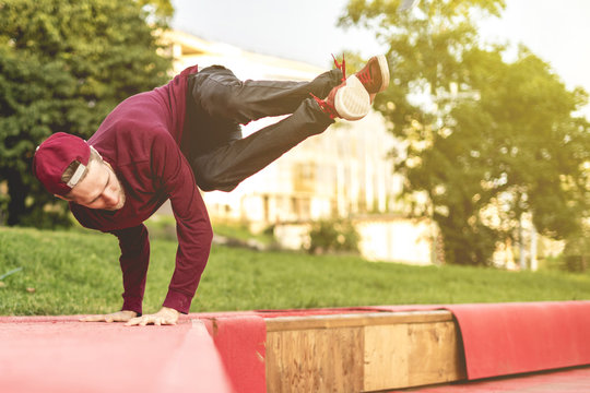 young man tracer in causual doing parkour in city on a summer day