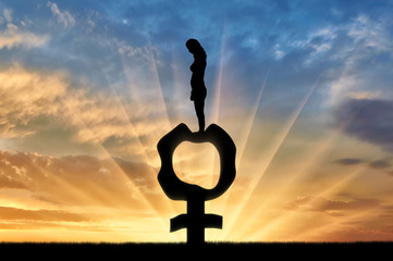 Silhouette of a sad woman standing on a female gender symbol that became flabby and wrinkled