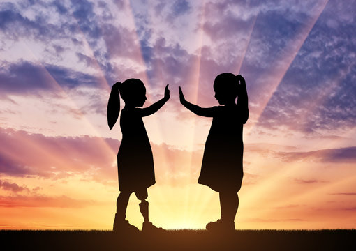 The Child Is A Disabled Girl With A Prosthetic Leg And Her Friend In The Open Air At Sunset