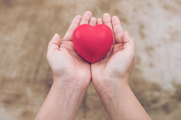 Fototapeta premium Red heart ball : Stress reliever foam ball the red heart shape on woman hand. Gift valentine's Day