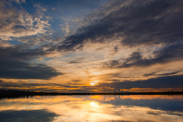 Sunset in the lake. beautiful sunset behind the clouds above the over lake landscape background. dramatic sky with cloud at sunset