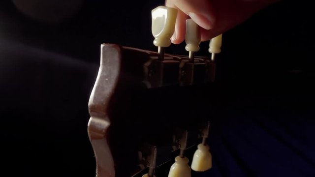 Person tuning an electric guitar