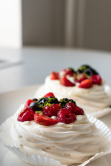 Florence, Tuscany / Italy In 2018, Augst 19.  dessert Pavlova with vanilla cream, Pavlos with raspberries and blueberries. Italian restaurant, gourmet dessert. cake on white background, isolated