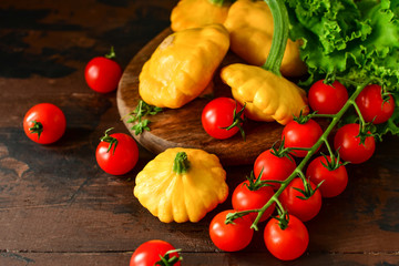 pumpkins with cherry tomatoes and salad on a wooden table. a new harvest of vegetables from the garden, vegan food, a diet food. selective focus and copy space