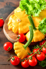 pumpkins with cherry tomatoes and salad on a wooden table. a new harvest of vegetables from the garden, vegan food, a diet food. selective focus and copy space
