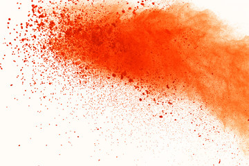 Abstract of colored powder explosion on white background. Orange powder splatted isolate. Colorful...