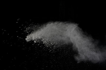 Naklejka premium White powder explosion isolated on black background. Colored dust splatted.