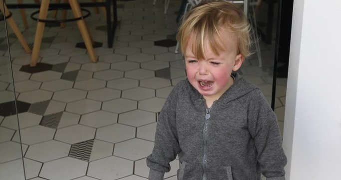Children's hysteria in the cafe. Cute little Caucasian boy crying close up