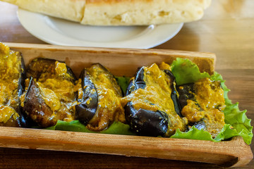 Fried aubergines with nut filling in a bowl of bamboo trunk. Aubergines in Georgian.