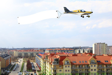 Samolot, awionetka z bilbordem reklamowym nad miastem Wrocław.