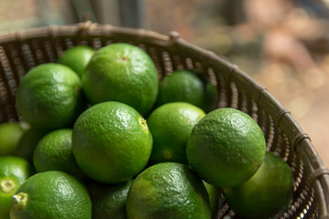 Lime Citrus Fruits in bamboo basket background. Fresh juicy limes. Healthy food