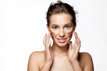Girl with peeling cosmetic product on beauty face on white background. Smiling female doing spa...