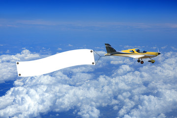 Samolot, awionetka z bilbordem reklamowym nad chmurami. - obrazy, fototapety, plakaty