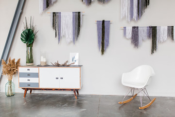 White scandinavian interior decor closeup. White chair bureau Dream catchers house plants