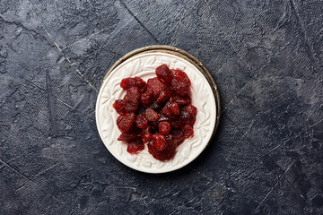 Dried sweet strawberry on a black background. Top view of a candied berries.