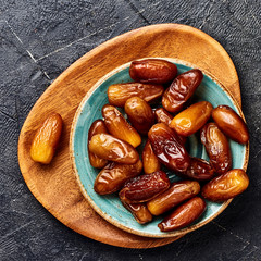 Dried dates fruits on plate. Top view of pitted dates.
