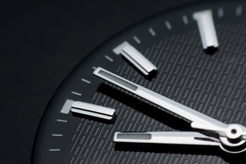 Close up clockwise on black clock face background. Wristwatch in retro style