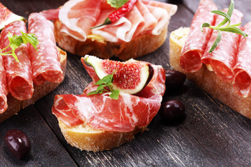 Sandwich with prosciutto or salami or crudo. Antipasti gourmet bruschetta snack.
