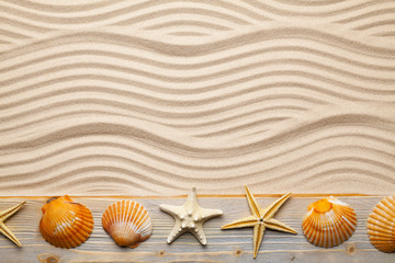 Fototapeta na wymiar Marine symbols - beach sand and starfish and shell on old wooden plank