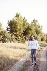 Obraz premium Young woman standing on a wheat field with sunrise on the background