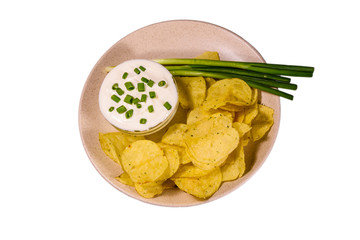 Ceramic plate with potato chips and glass bowl with sour cream isolated on a white background
