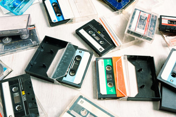 Vintage audio cassette on a wooden background. Collection of various retro audio tapes  - obrazy, fototapety, plakaty