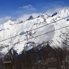 Ski resort with chair lift and snow mountains at nice sunny day