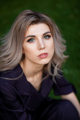 vertical Portrait of a blonde woman on a dark green background