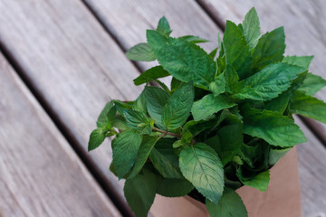 A bouquet of mint in a craft pack on a wooden surface