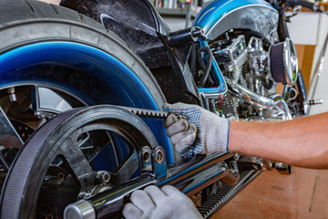 Fototapeta na wymiar Side view portrait of man working in garage repairing motorcycle