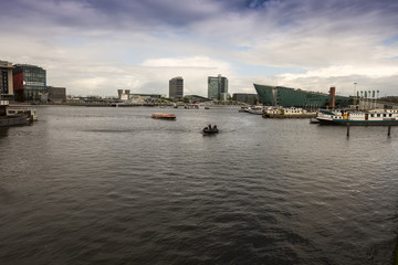 Fototapeta na wymiar Amsterdam Oosterdok. Harbour near Amsterdam Centraal Station and NEMO Science Museum