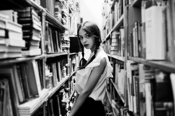 Girl with pigtails in white blouse at old library.