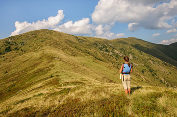 girl with a big backpack rises to the mountains. Ukraine