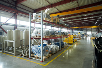 Wide angle shot of empty factory warehouse with tall shelves, copy space