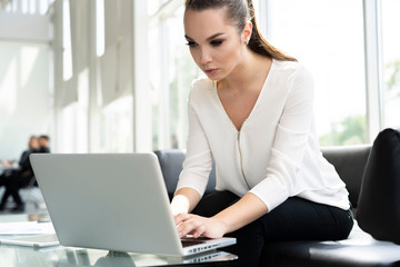 Portrait of a serious businesswoman using laptop in office.