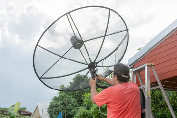 Man technicians are installing satellite dish on roof. Satellite Installer