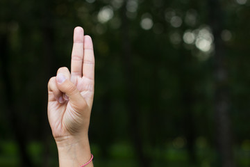 signs and symbols for people with disabilities mute and deaf humans concept of dactyl alphabet by female hand and fingers with empty space for copy or text on unfocused dark background