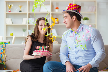 Young couple celebrating birthday with cake