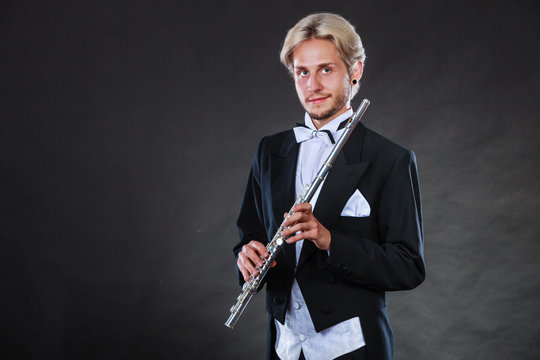 Elegantly dressed musician holding flute