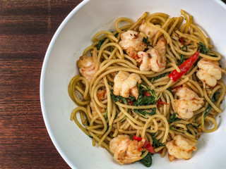 Top view of the spicy shrimp spaghetti, Asian style. On the wooden top table.