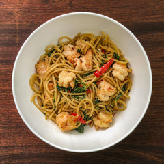 Top view of the spicy shrimp spaghetti, Asian style. On the wooden top table.