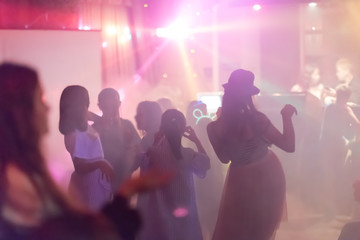 Fototapeta na wymiar blur Light in club party Show And Silhouette hands of audience crowd people use smart phones enjoying the club party with concert. Blurry night club DJ party people enjoy of music dancing sound.