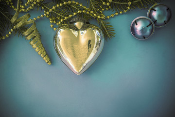 Beautiful christmas background with fir branch, golden heart and decorations on blue