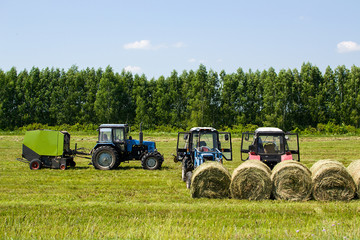 tractors are on the field, the season of hay