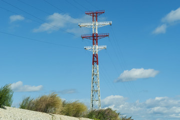 Obraz premium high-voltage power line support painted in red and white colors, against the sky