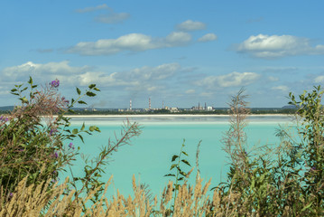 Fototapeta na wymiar industrial tailing pond with beautiful blue water on the background of the factory landscape