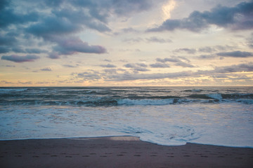 Obraz premium Horizon to shore waves at a cloudy, colourful sunset in Central America