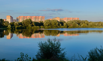 Fototapeta na wymiar New microdistrict of the Swedish Hill in Gomel. Late evening. Summer sunset. Lake. Belarus