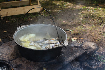 hike. fish soup in a pot in the fire