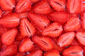 Fresh strawberry slice red background. Summer background texture of sliced strawberries.